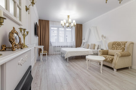 Interior in light colors with a bio fireplace, illuminated by burning sconces on the wall.の写真素材