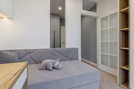 A modern teenager's room, with a sofa, a desk and a large window.の写真素材