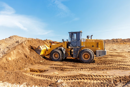 Heavy Loader Transporting Earth at Urban Construction Siteの写真素材