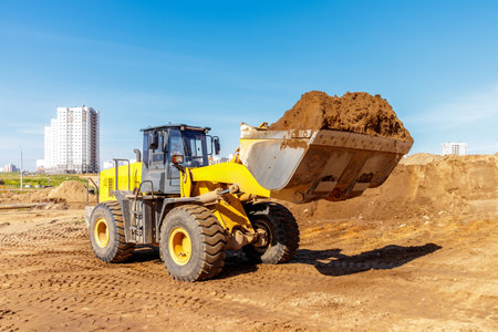 Heavy Loader Transporting Earth at Urban Construction Siteの写真素材