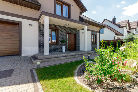 A beautifully designed modern house, featuring brick details, a landscaped yard, and a welcoming...