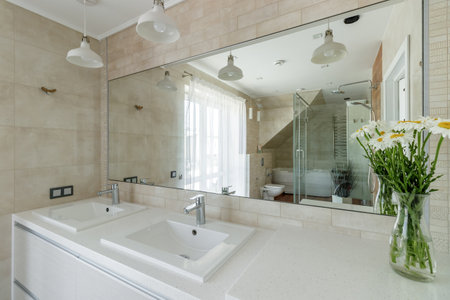 A modern bathroom featuring elegant fixtures, wooden floors, and ample natural light for a serene and spa-like atmosphere.の写真素材