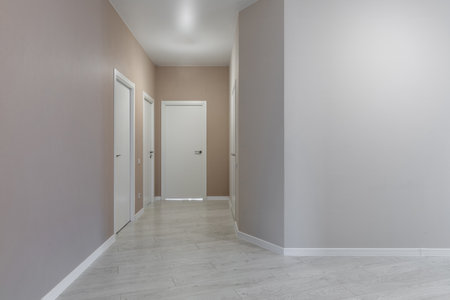 Bright hallway with white doors and laminate flooring in modern residential interiorの写真素材