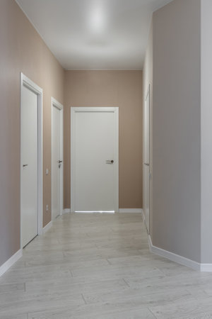 Bright hallway with white doors and laminate flooring in modern residential interiorの写真素材