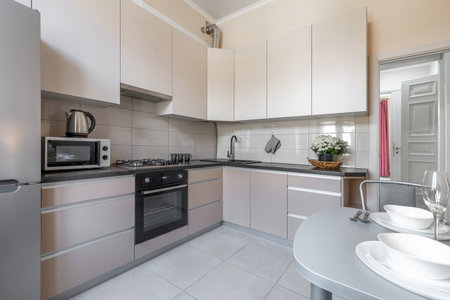 Modern Beige Kitchen with Dining Space and Black Countertopの写真素材