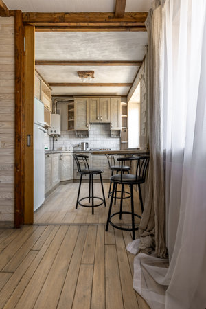 Bright Rustic Kitchen Interior with Wooden Cabinets and Bar Stoolsの写真素材