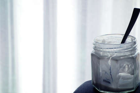 Empty yogurt jar with a spoon.の写真素材