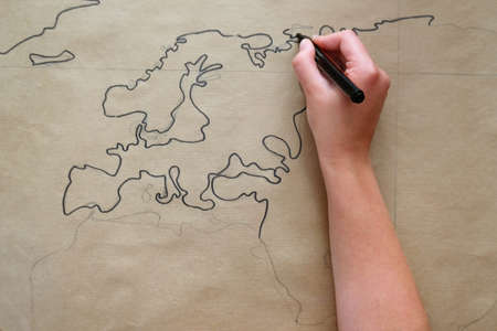 woman's hand measuring and drawing on brown kraft paper.の写真素材