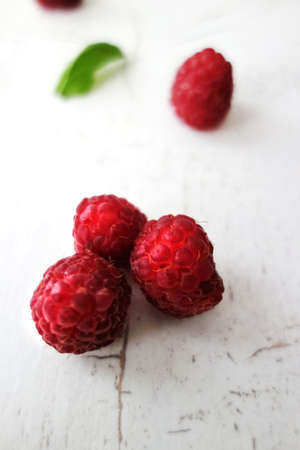 fresh ripe raspberries on white board close-up