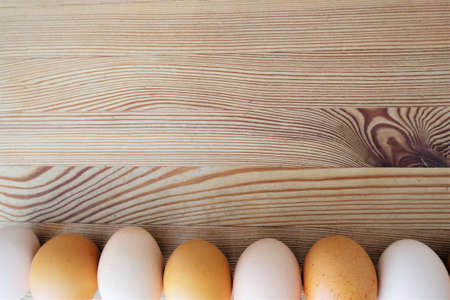 flatlay with a line of eggs laid on an old wooden table background
