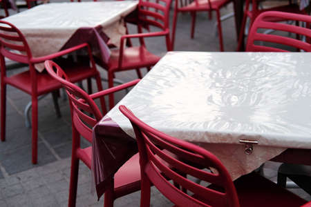 empty restaurant chairs and tables in bad weather in low season.の写真素材