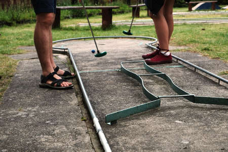 Man and woman playing miniature golf in summer