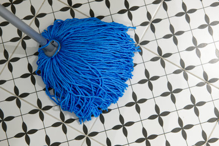 blue mop brush on black and white bathroom floorの写真素材