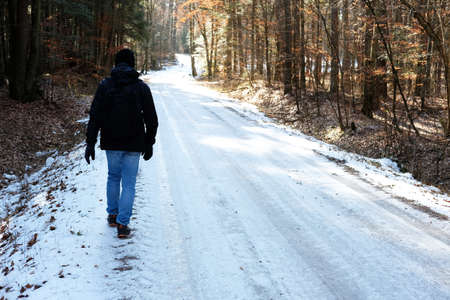 man on a hike on icy track in forest in ROztocze National Park in Poland in winterの写真素材