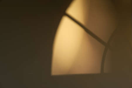 morning sun cast shadow on dark wall through old arch window - hope conceptの写真素材
