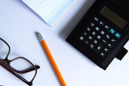 glasses, calculator on white paper - accounting conceptの写真素材
