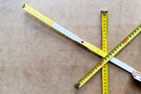 yellow measuring tapes on mdf background - carpentry cpnceptの写真素材