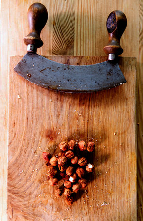 vintage cutter knife and nuts on wooden board - chopping nuts for healthy dessertの写真素材