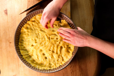 young caucasian woman hands push shortcrust pastry into a baking tin.の写真素材