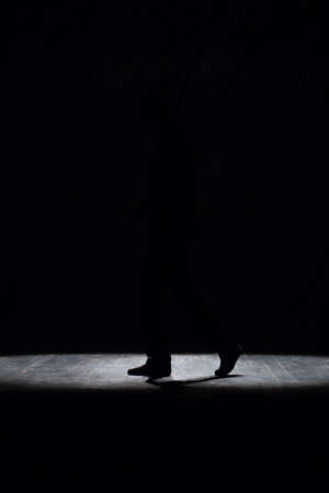Walking man in shoes on stage in the spotlightの写真素材