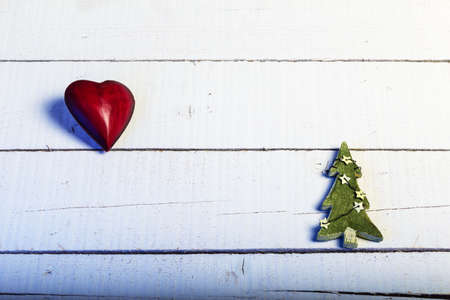 Red heart and green christmas tree on white woodの写真素材