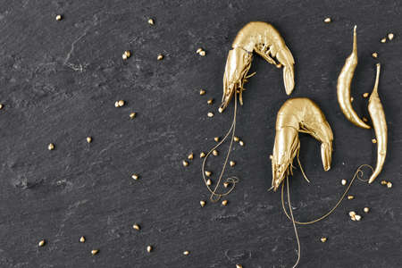 Luxury Golden Shrimps on black stone slate plate boardの写真素材