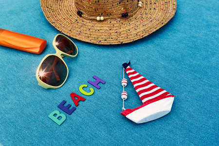 Top view of sandy beach with summer accessories with BEACH word.の写真素材