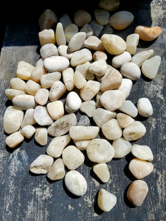 White pebbles on a dark background. Natural stone background.