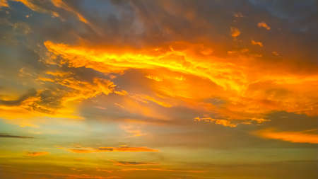 Fragment blue sky with clouds of red and yellow colors at sunset.の写真素材