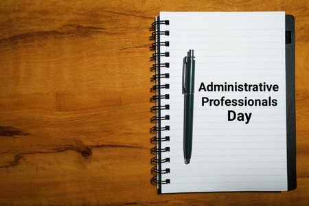 Administrative Professionals Day concept with notebook and pen on wood table background.の写真素材