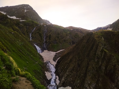 Beautiful mountain landscape with a waterfall in the middle of the valleyの写真素材