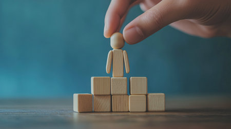 Businessman hand placing wooden cube block on top of wooden podium. Career growth concept.の素材
