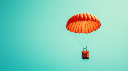 Parachutist flying in the blue sky with orange parachute.の素材