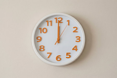 White wall clock showing 10 o'clock on white wall background.の素材