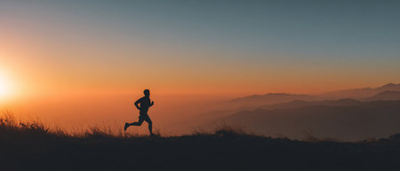 Silhouette of a man running in the mountains at sunset.の素材