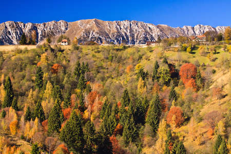Mountain autumn landscape with colorful forest and traditional housesの写真素材
