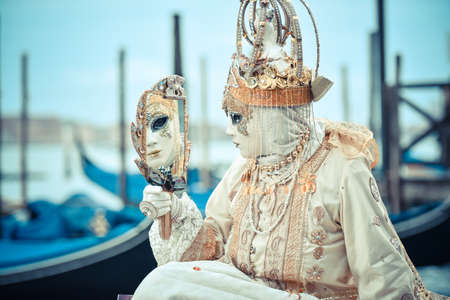 Beautifull Venetian masked model from the Venice Carnival 2015 with Gondolas in the backgroundの写真素材