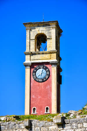 The clock tower of the old fortress in Corfu Town on top of the old Kerkyra venetian fortress.の写真素材