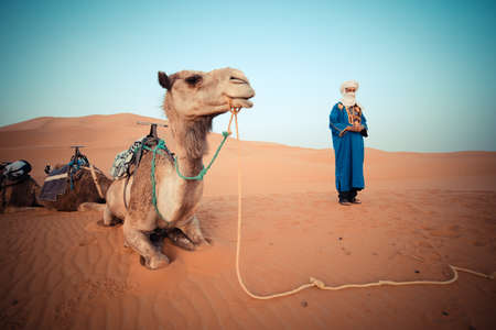 SAHARA DESERT, MOROCCO, JUNE 2016: berber in traditional clothes with camel in daily trips with...