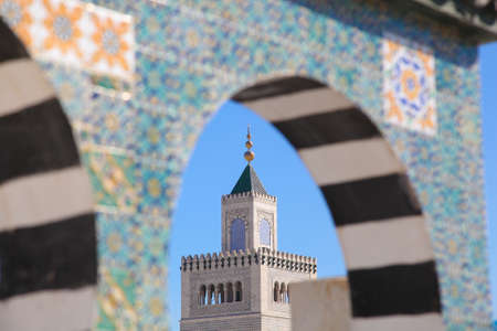 Mosque tower and Islamic ceramic decoration patterns on the wall in Tunis, the capital of Tunisia. Mosque in the background. Focus on the Mosque tower.の写真素材