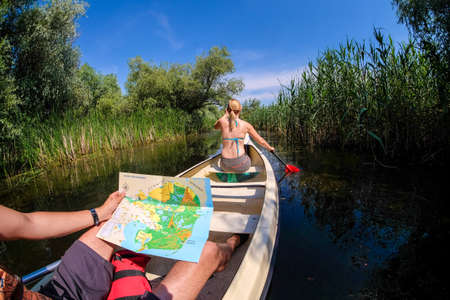 Danube Delta, Romania, June 2017: Tourists exploring Danube Delta in a boat looking at a mapのeditorial素材