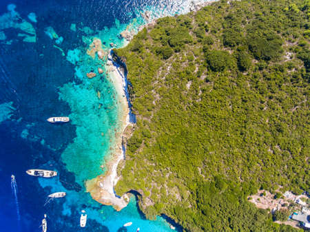 Antipaxos Island, Greece, with sandy beach, yachts docked in the ethereal clear blue waters of the Ioanian island near Corfuの写真素材