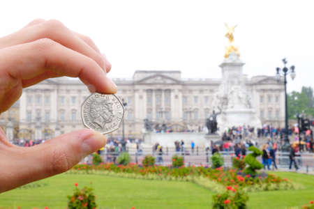 English coin picturing the Queen in front of Buckingham Palace. Focus on the coin. Artistic interpretation.のeditorial素材