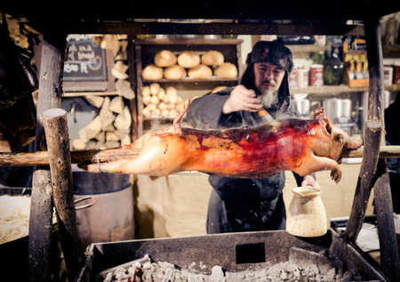 BUDAPEST, HUNGARY - 8 DECEMBER 2016: Budapest Christmas market street food vendor cooking roasted...