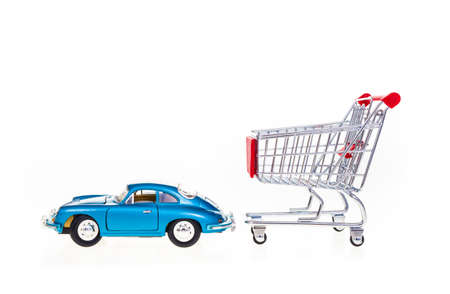 Car pulling shopping cart conceptual image isolated on white backgroundの写真素材