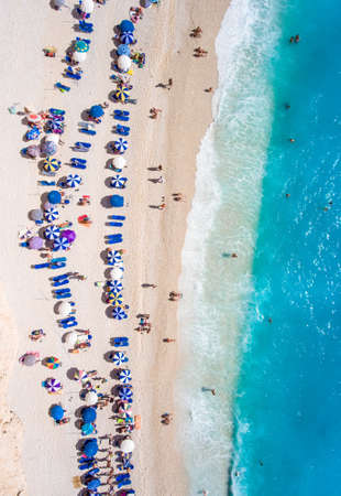 Tourists relaxing on the Egremni Beach in Lefkada swimming and playing games in the waterの写真素材