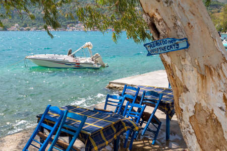Traditional old Greek fishing boats. Sign reads: pleas do not feed the catsの写真素材