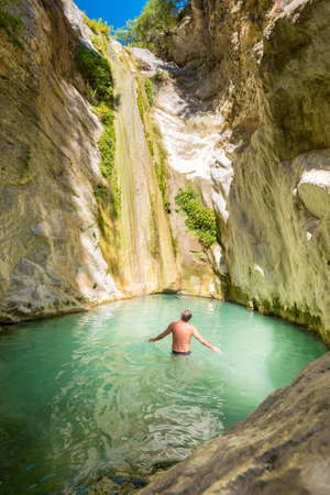 Tourist taking a bath inside Nidri Waterfall in Lefkada Greeceの写真素材