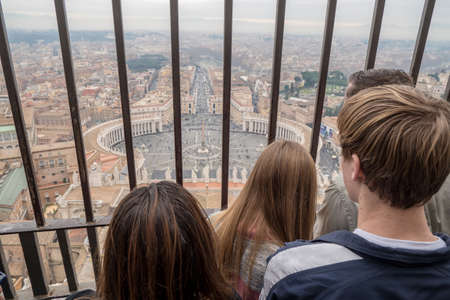 Tourists enjoying the view of Rome skyline from the top of St. Peter's Basilica in Rome, Italy
