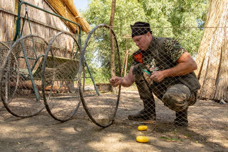 Danube Delta, Romania, May 2018: Traditional fisherman in Danube Delta working on his fishing net in an old fishing camp in the Deltaのeditorial素材